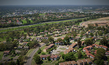 An aerial view of housing in NSW surrounded by trees